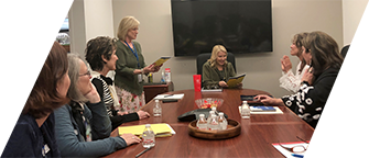 Seven DVU board members sit around a conference table meeting with DDS Director Nancy Bargmann, who sits at the head of the table