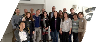 The DVU board and staff pose on a staircase, smiling and wearing nametags