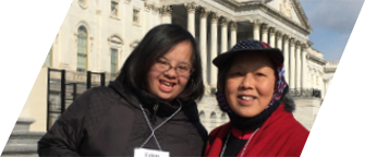 A young Asian woman with Down syndrome and her mother smile in front of the United States Capitol
