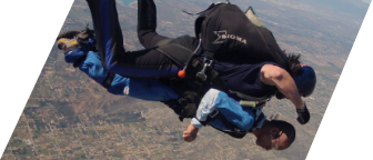 A man with a disability skydiving, strapped to an instructor